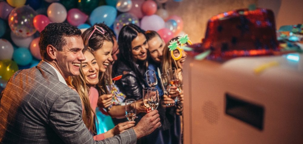 Photobooth in actie op een feest, verhuurd door Brand Booth photobooth verhuur. Mensen lachen en vieren feest.